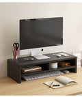 Black wooden monitor stand riser with storage shelves on a light wood desk