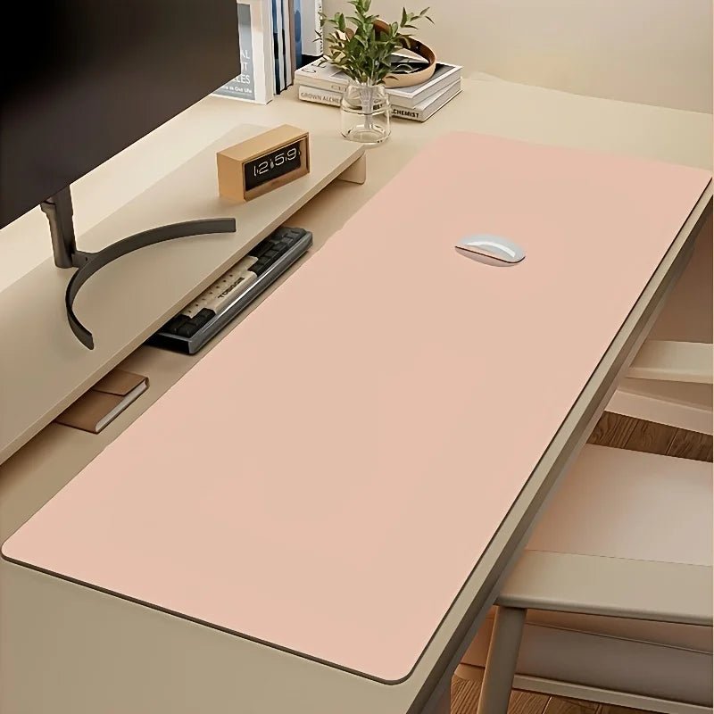 Blush pink extended desk mat with a white mouse on a modern workspace.