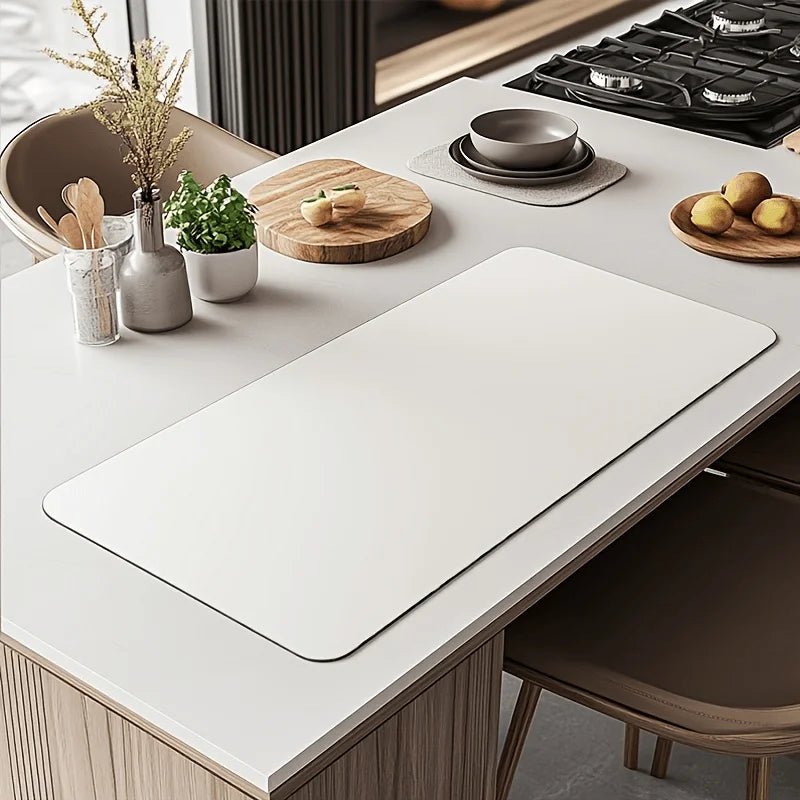 Large white desk mat on a clean white workspace with minimalist kitchen decor.