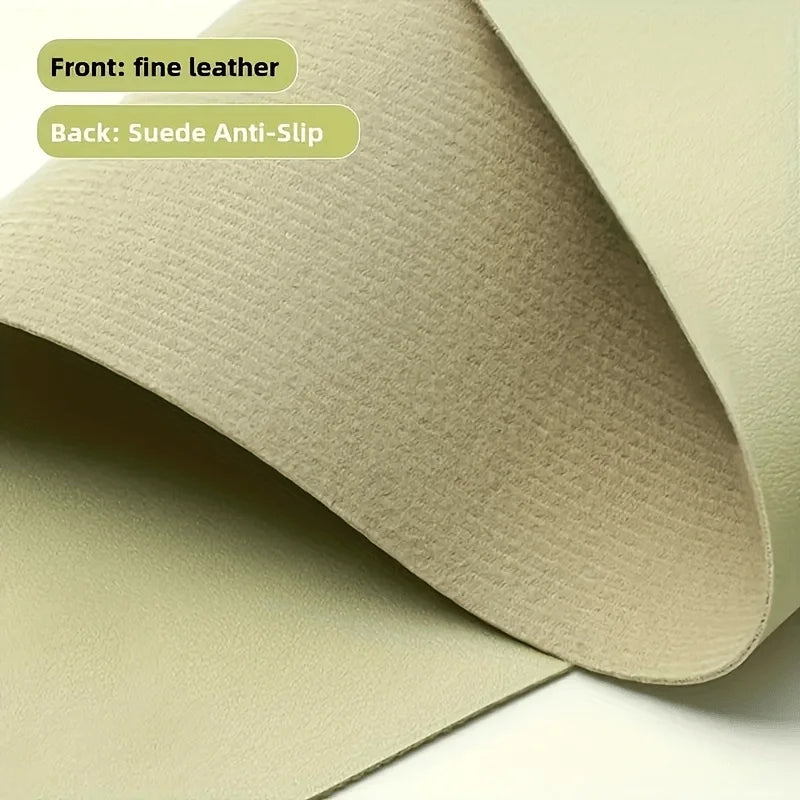 Close-up of a sage green desk mat showing fine leather front and suede anti-slip back.