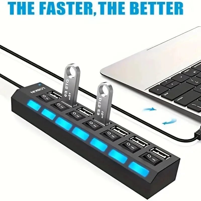 Black USB hub with blue LED lighting and two USB drives plugged in next to a laptop.